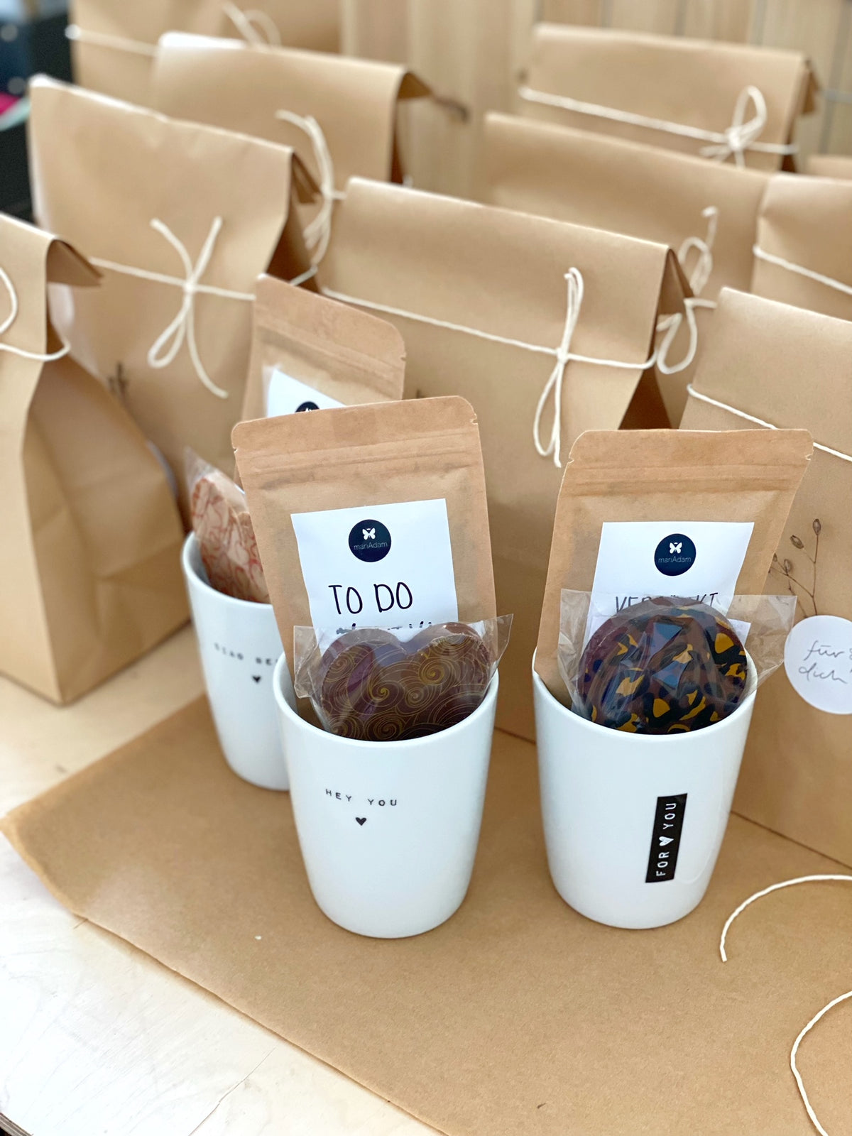 Geschenktüten für Mitarbeiter in natürlich, klaren Stil. Gefüllt mit Bechern, Schokoladen und Gewürzen. Erhältlich im Conceptstore Stadtrandstil
