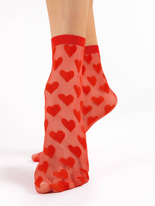 Rote Tüllsocken am Fuß mit rot aufgestickten Herzen