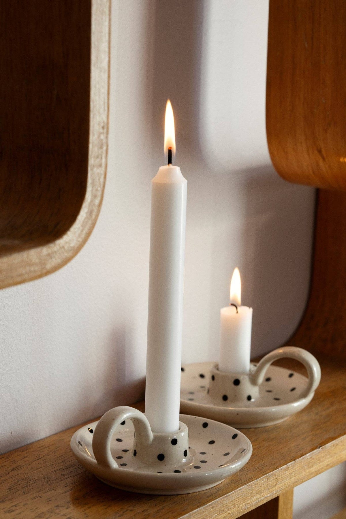 zwei Kerzenhalter mit weißen brennenden Kerzen in gepunkteten Kerzenständern von moshimoshi