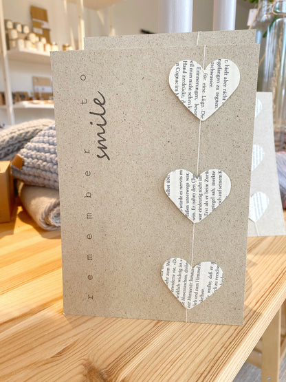 Graspapier karte mit herz Girlande aus recycelten Buchseiten