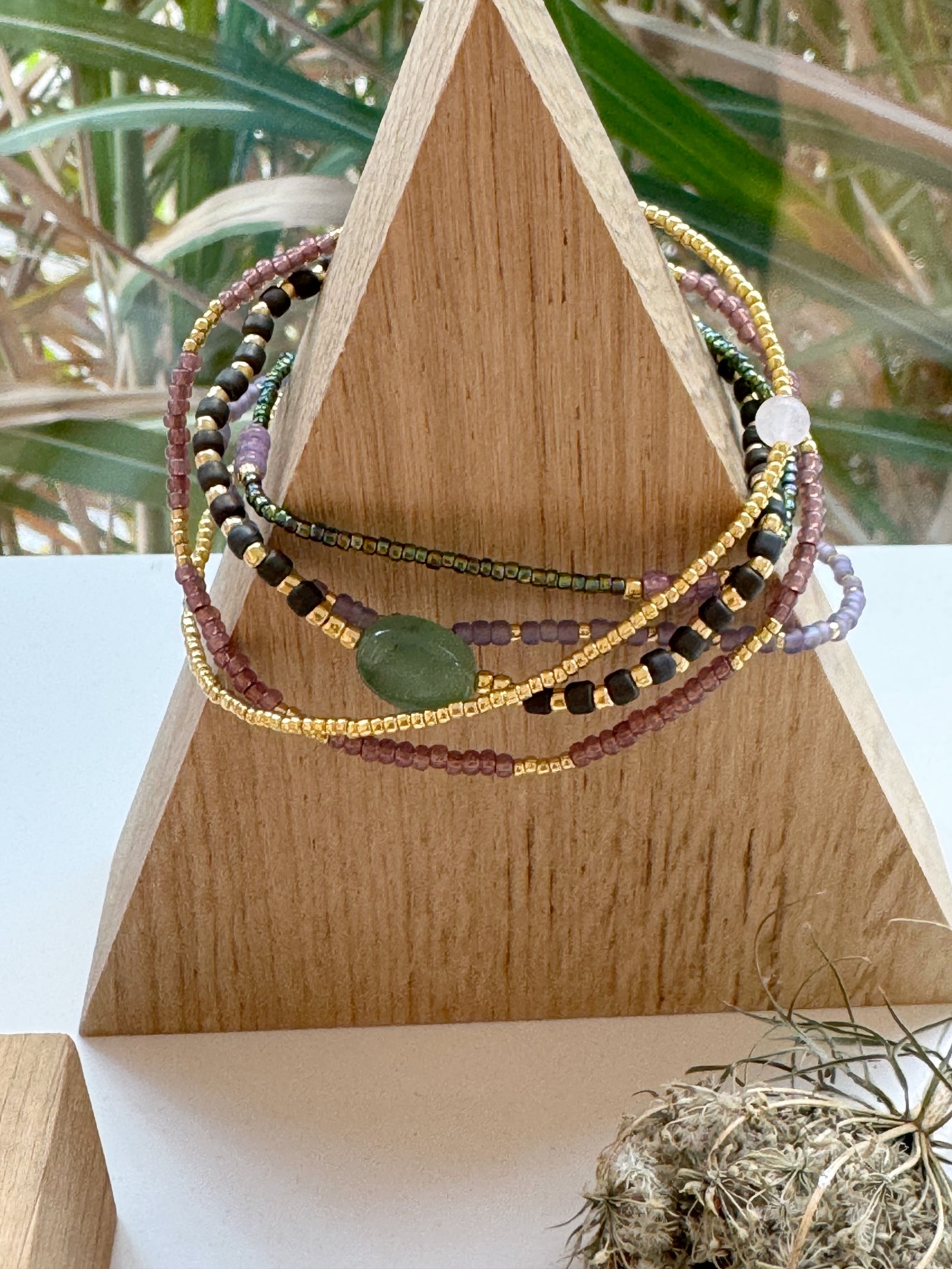 grün-brombeerfarbenes Armband aus Glasperlen und Labradorit auf Holzständer