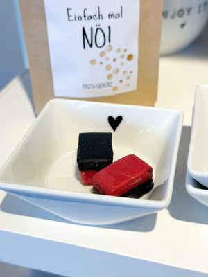 Minischale aus Porzellan gefüllt mit zwei Himbeer-Lakritz Stücken