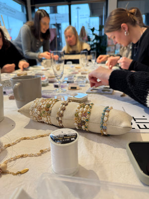Frauen am Tisch, die Armbnder gestalten