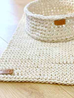 Detailaufnahme eines naturweißen, gehäkeltem Badvorleger und dem passenden Korb von Stadtrandstil handmade. mit Lederlabel.