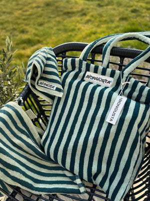 grün gestreifter shopper und handtücher auf gartenstuhl