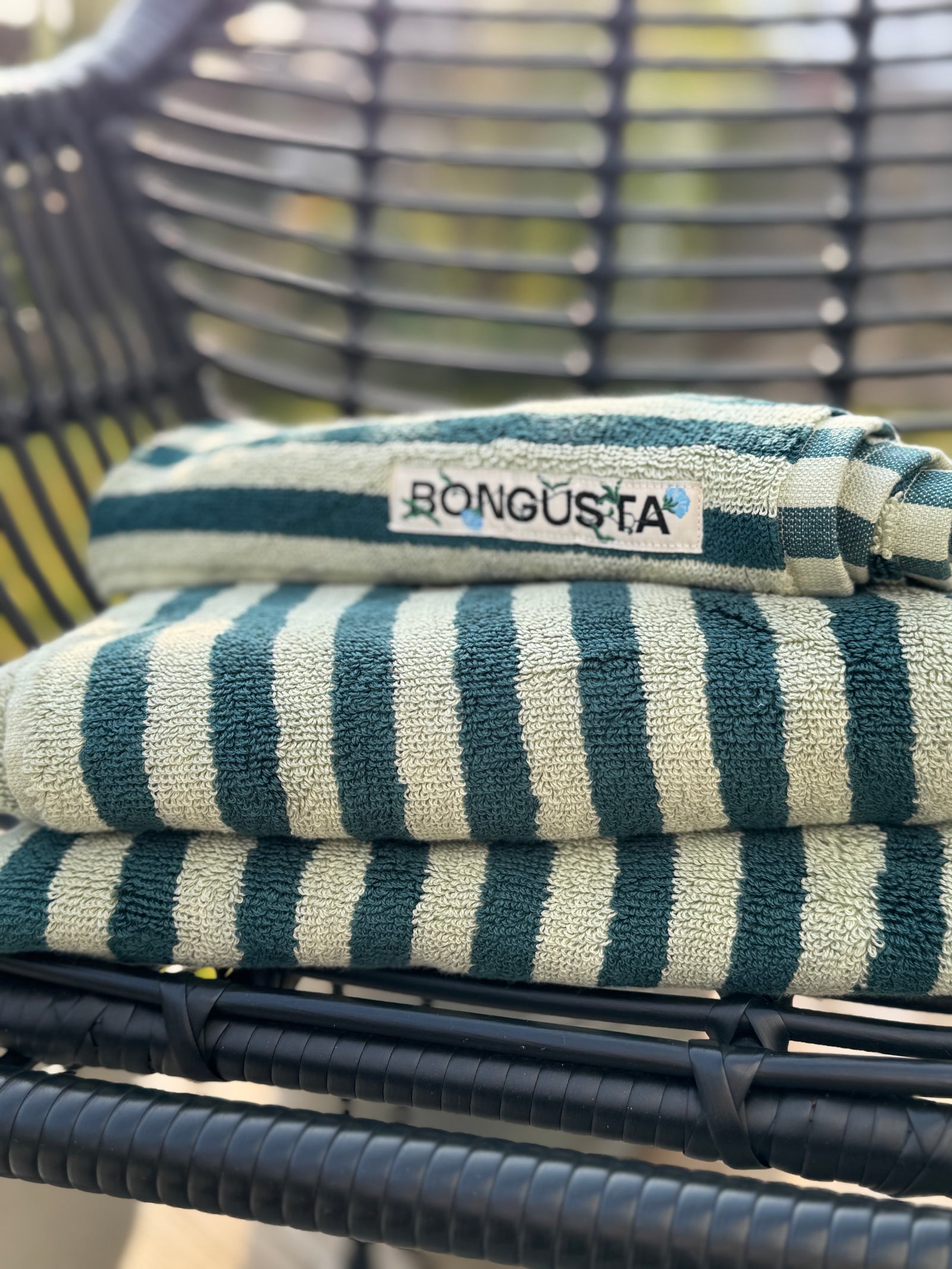 Handtücher und Taschen mit fröhlichen Streifen in einem Regal