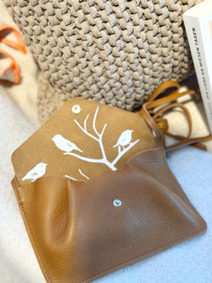 Kleine, bruane Tasche Backing Vocals vor Strickkissen