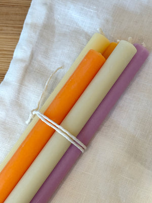 Detailaufnahme von 5 dünnen Kerzen in Frühlingsfarben