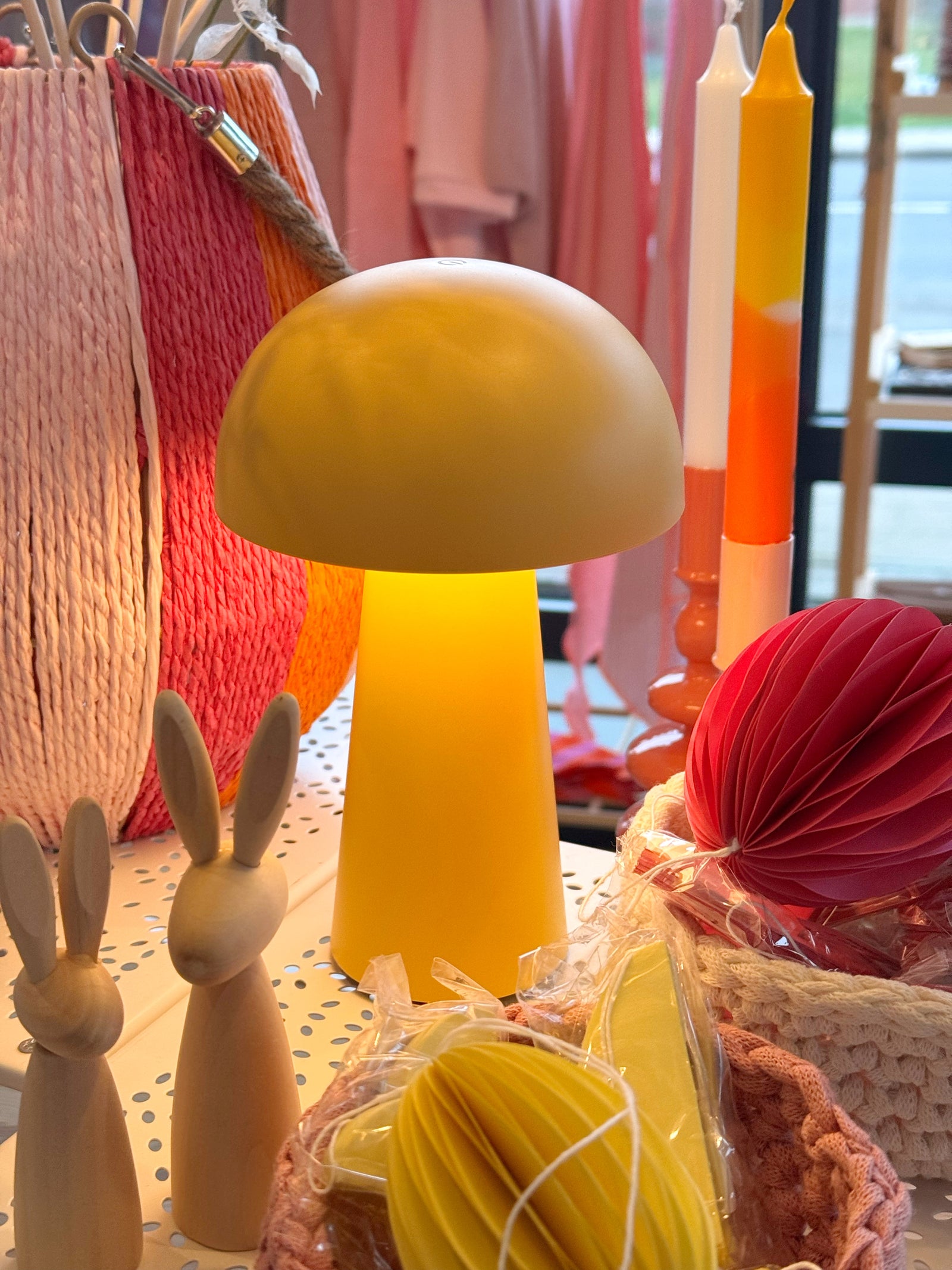 gelbe tragbare lampe in Pilzform, die angeschaltet ein sanftes licht macht, dekoriert mit Osterartikeln