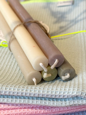 5 naturfarbene, schmale Kerzen auf Geschirrtuch