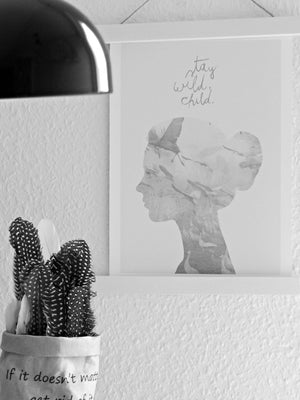 Moodfoto : weiße Posterleiste mit Poster "stay wild child" vor natürlichen Dekoelementen