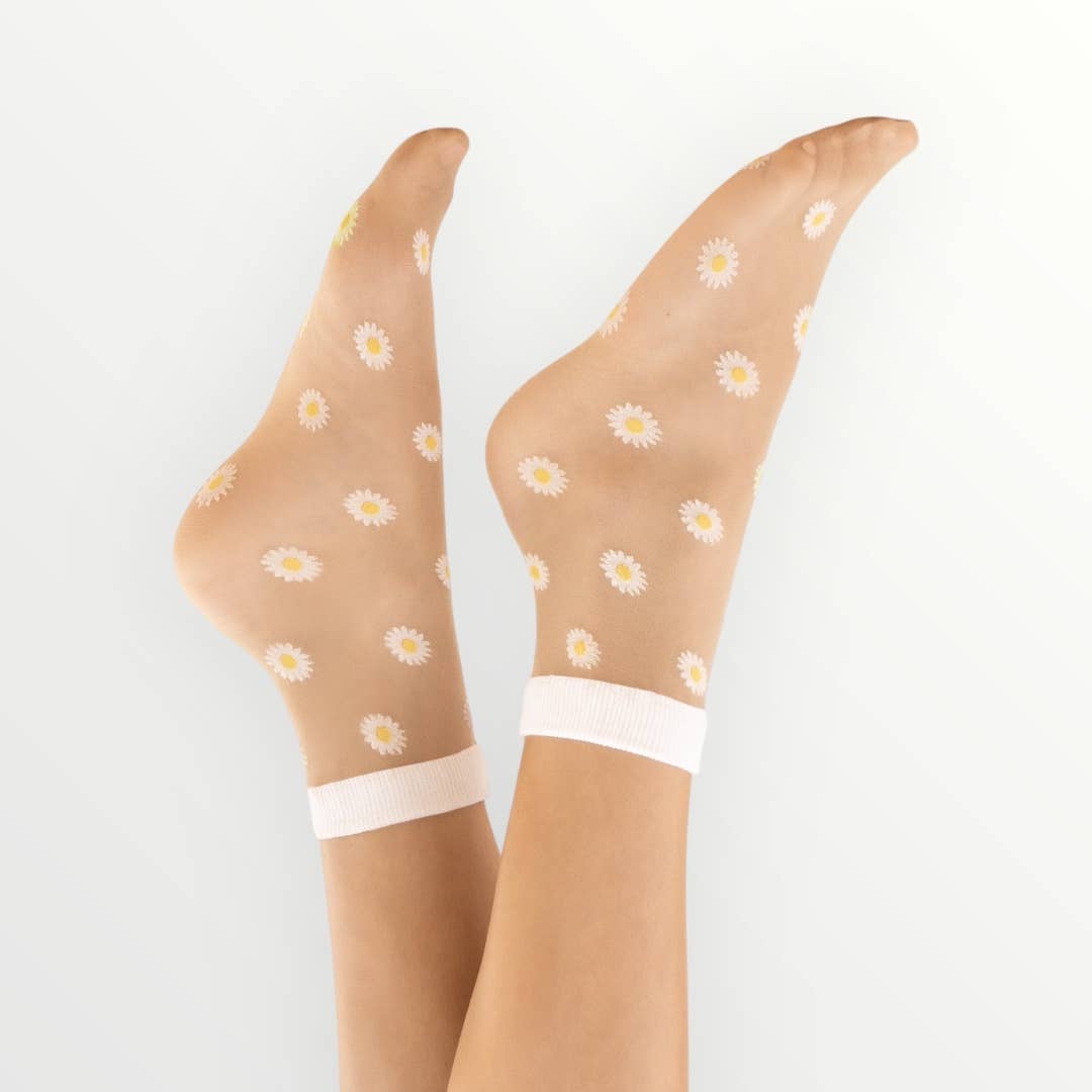 zwei Füße in durchsichtigen Tüllsocken mit Gänseblümchen Motiv