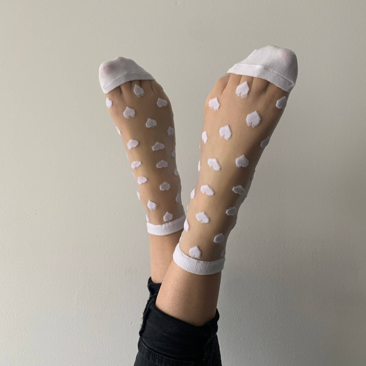 Tüllsocken mit weißen herzen an zwei fußen