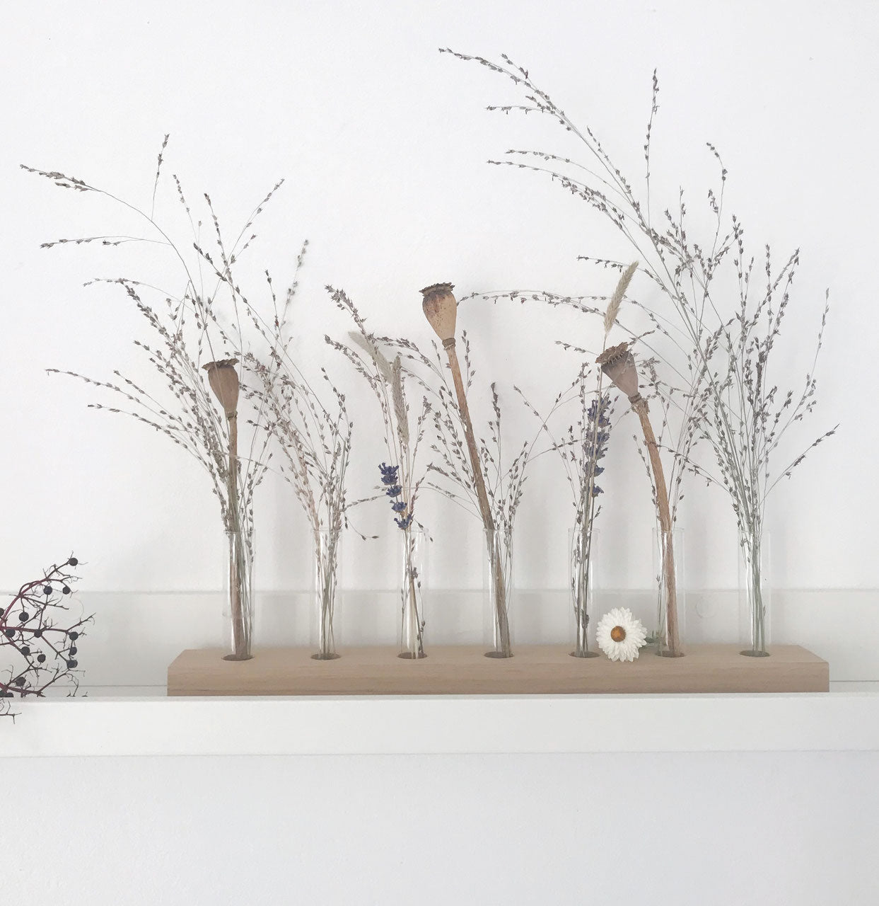 Blumenwiese/ Flowerbar mit sieben herausnehmbaren Reagenzgläsern von Stadtrandstil. Sehr natürlich dekoriert auf einem weißen Bord mit getrockneten Gräsern und Mohnkapseln