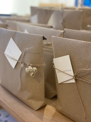 naturfarbene Geschenktüten mit trockenbmen und kleiner karte Firmengeschenke