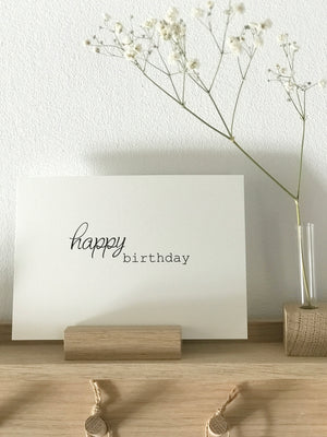 Postkarte mit dem Aufdruck "happy birthday", daneben eine Minivase mit einem Zweig Schleierkraut. Alles von Stadtrandstil handmade