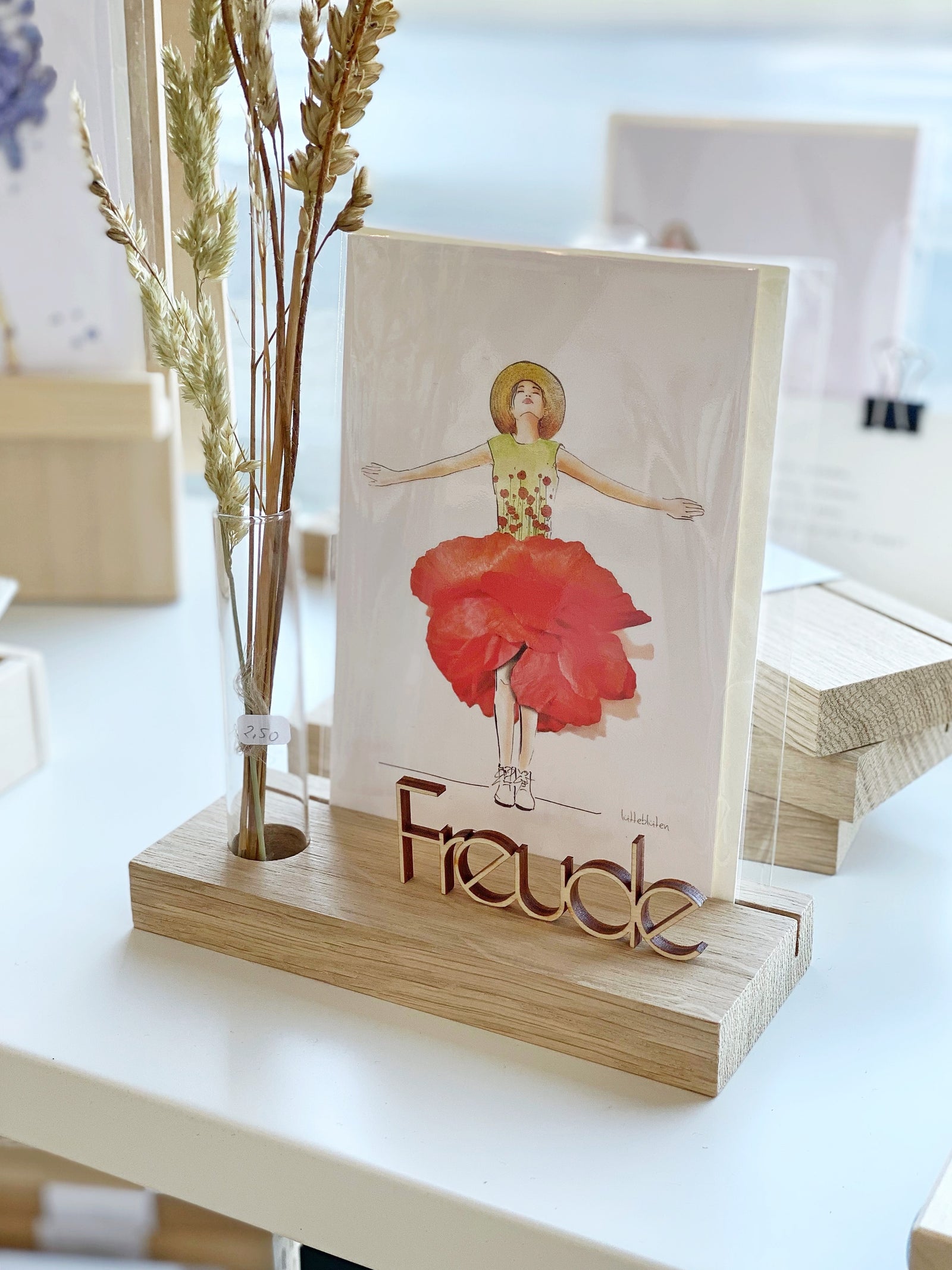 kleine Schriftzüge aus Holz "danke" und "freude" auf einem KAlenderhalter mit einem Reagenzglas und Tulpe