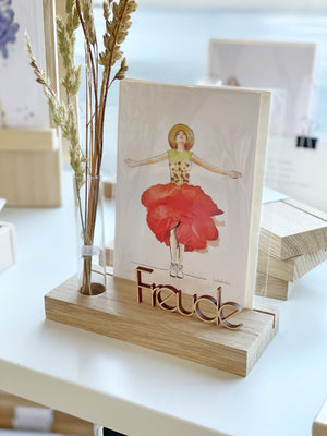 Kartenhalter "flowers", dekoriert mit einer Karte mit einer Frauenfigur, getrockneten Gräsern im Reagenzglas und einem kleinen Schritzug "Freude"