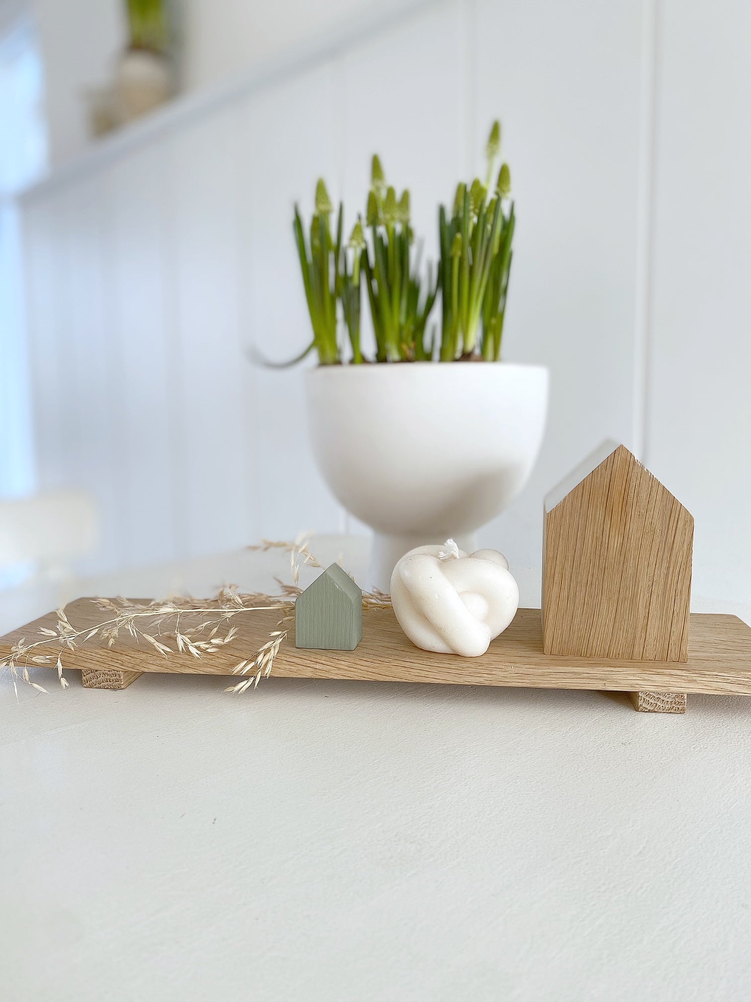 NAtürliche Dekorations Inspiration mit dem kleinen Tablett von Stadtrandstil und weiterer, skandinavisch angehauchten Elementen wie zwei Dekohäusern. Kerze und bepflanzer Schale