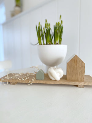 NAtürliche Dekorations Inspiration mit dem kleinen Tablett von Stadtrandstil und weiterer, skandinavisch angehauchten Elementen wie zwei Dekohäusern. Kerze und bepflanzer Schale