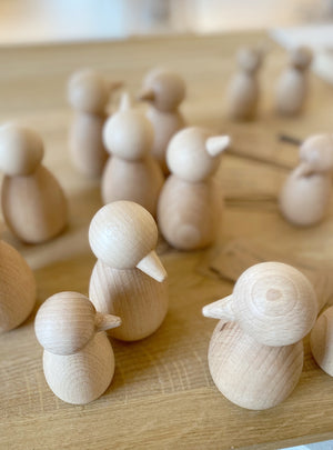 Holztisch voller minimalisischer Holzvögel in zwei Größen